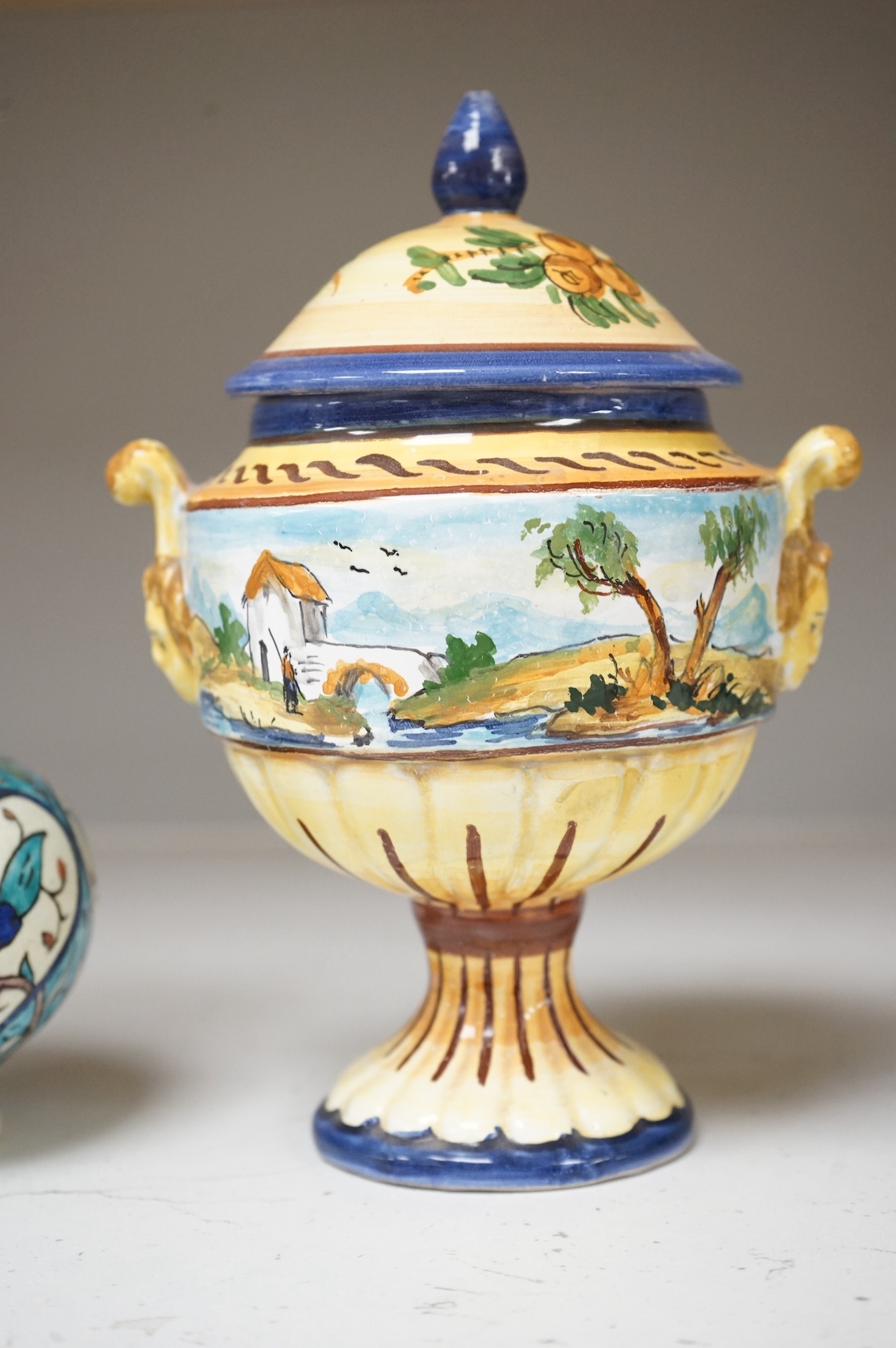 A pair of Isnik pottery vases and majolica vase and cover, largest 22cm high. Condition - fair, some restoration